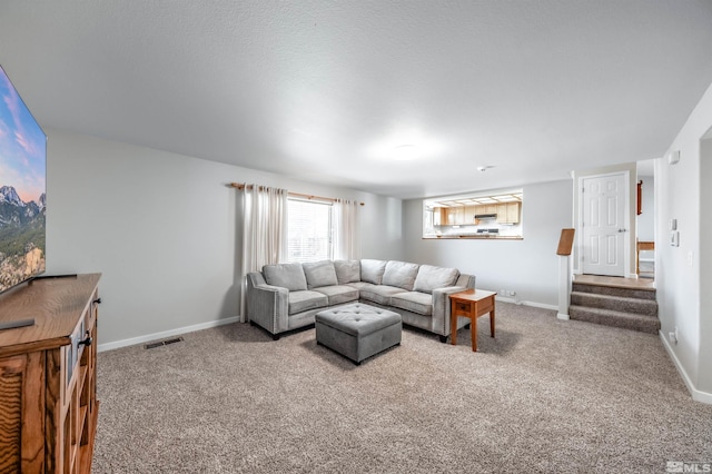 living area featuring stairs, carpet floors, visible vents, and baseboards