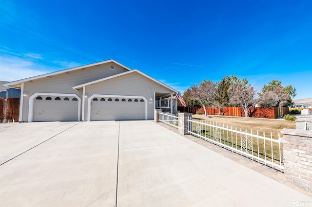 view of front of house featuring a garage, concrete driveway, and fence