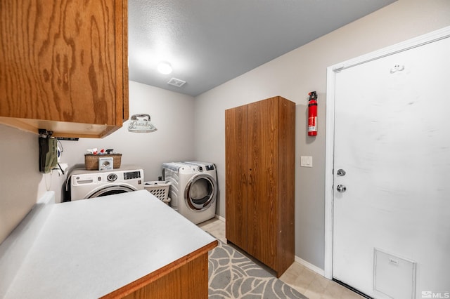 washroom featuring light floors, cabinet space, visible vents, washer and dryer, and baseboards