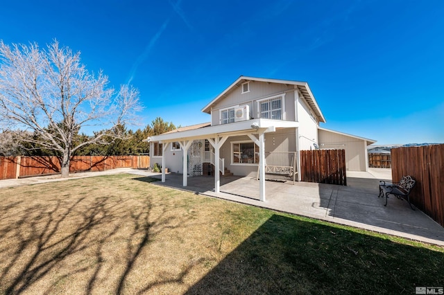 rear view of property with a yard, a fenced backyard, and a patio