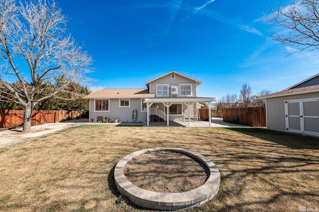 back of house featuring a yard, fence private yard, a patio, and an outdoor structure