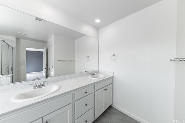 bathroom featuring a stall shower, visible vents, a sink, and double vanity