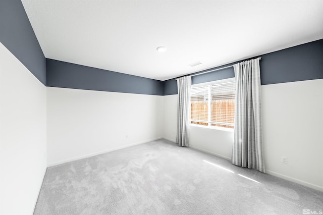 carpeted spare room featuring baseboards