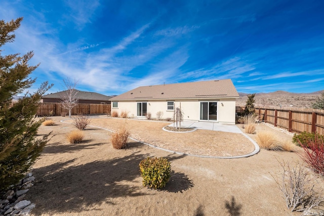 rear view of house with a patio, a fenced backyard, and stucco siding