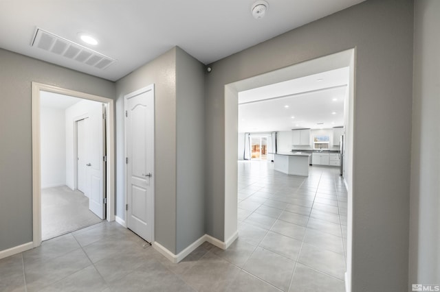 hall with recessed lighting, visible vents, baseboards, and light tile patterned floors