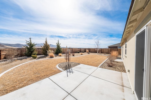 view of patio with a fenced backyard and a mountain view