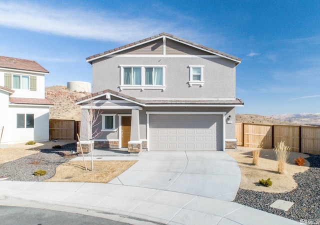 view of front of house featuring concrete driveway, an attached garage, fence, and stucco siding