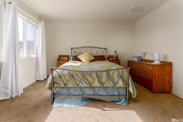 carpeted bedroom with visible vents and baseboards