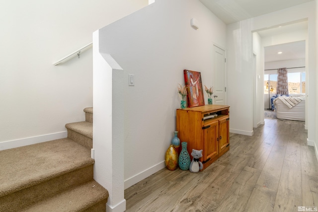 stairway featuring wood finished floors and baseboards