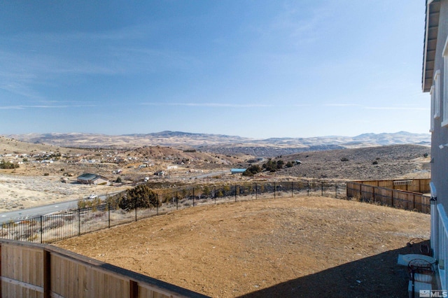 view of yard featuring a mountain view and fence