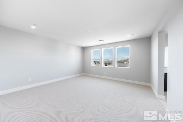 empty room featuring recessed lighting, light colored carpet, visible vents, and baseboards