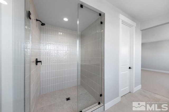 bathroom featuring a tile shower and baseboards