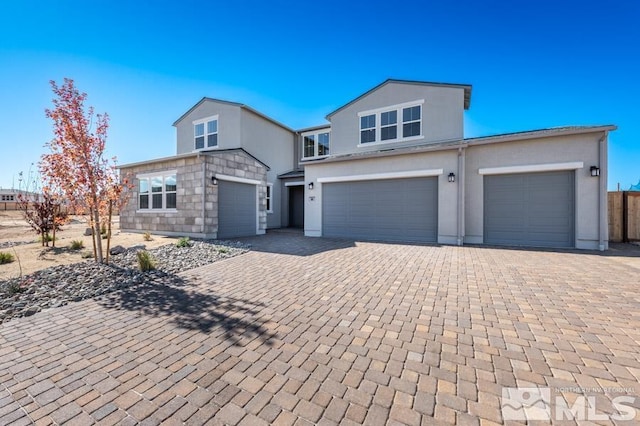 view of front of home featuring decorative driveway and stucco siding