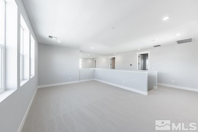 empty room with baseboards, light colored carpet, visible vents, and recessed lighting