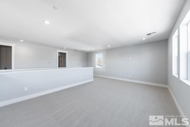 carpeted spare room with baseboards, visible vents, and recessed lighting