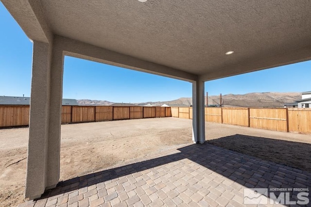 view of patio featuring a fenced backyard and a mountain view