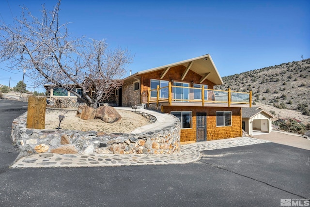 view of front of property featuring driveway and a balcony