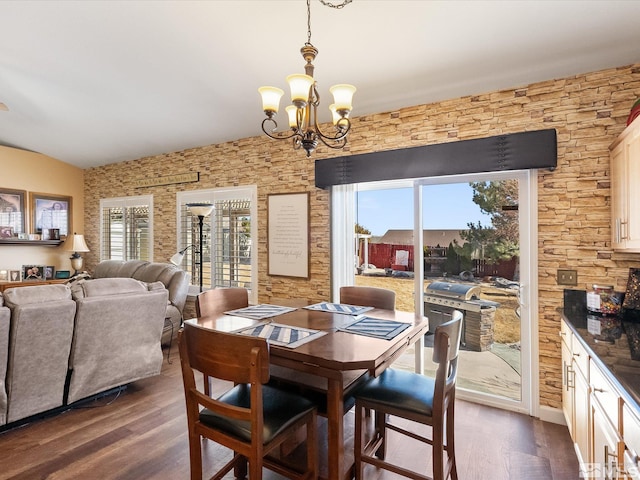 dining area featuring a healthy amount of sunlight, an inviting chandelier, and dark wood-style flooring