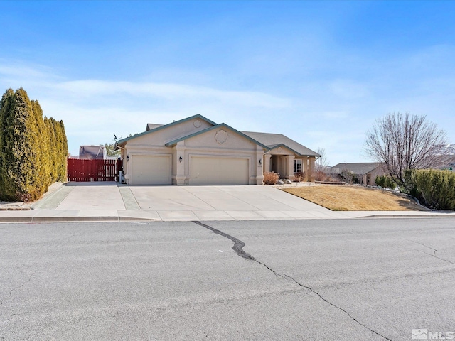 ranch-style home with a garage, fence, concrete driveway, and stucco siding