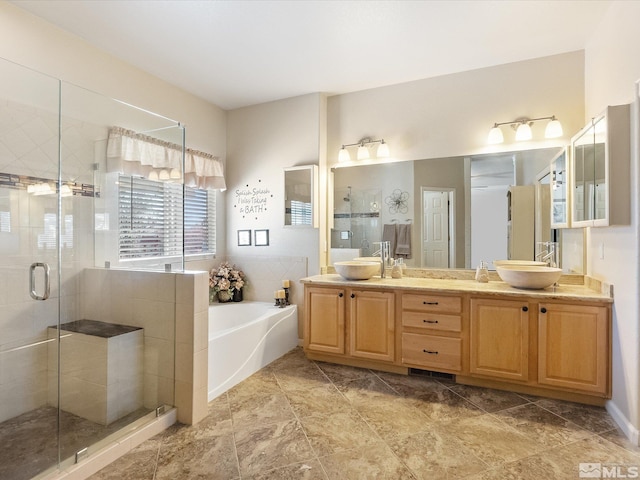 full bathroom featuring a stall shower, double vanity, a sink, and a bath