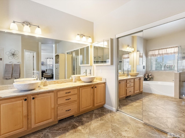 bathroom with a garden tub, a sink, and double vanity