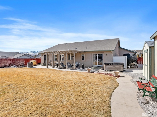 back of property with stucco siding, a patio area, a fenced backyard, and a hot tub