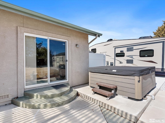 view of patio / terrace with entry steps and a hot tub