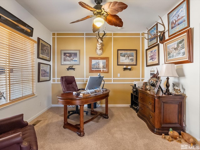 home office with baseboards, a ceiling fan, and light colored carpet