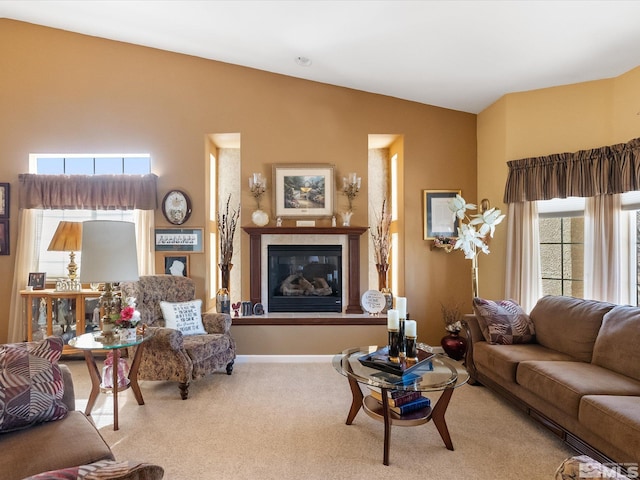 living room featuring carpet, baseboards, vaulted ceiling, and a glass covered fireplace