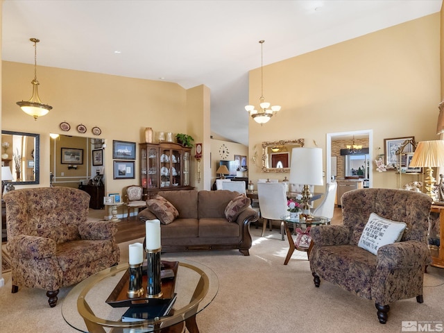 living area with high vaulted ceiling, carpet flooring, and an inviting chandelier