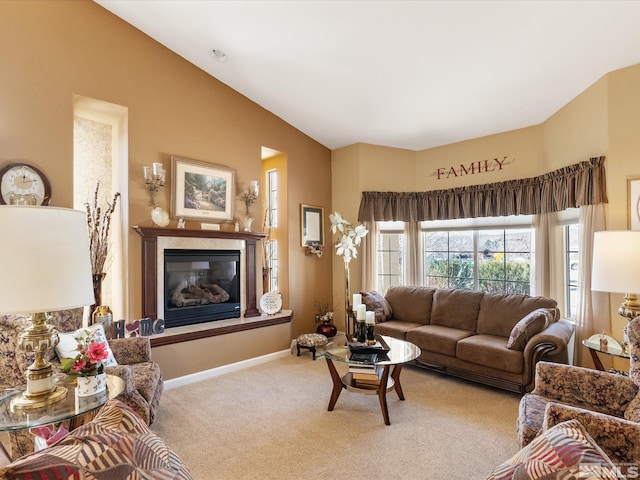 carpeted living room with a glass covered fireplace and baseboards