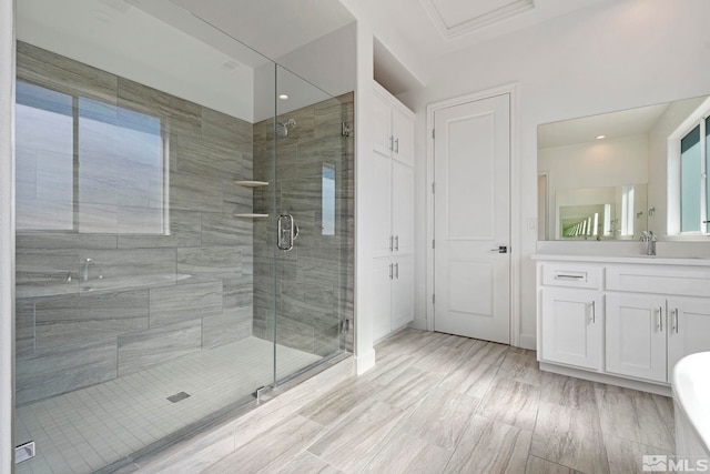 full bathroom with a stall shower, wood finished floors, and vanity