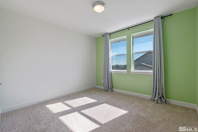 unfurnished room with carpet and baseboards