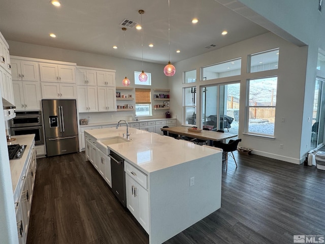 kitchen featuring dark wood-style floors, white cabinetry, appliances with stainless steel finishes, and a sink