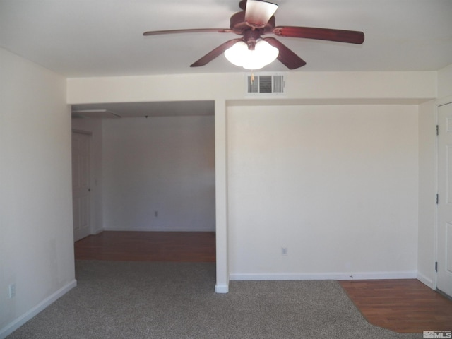 carpeted spare room featuring visible vents, ceiling fan, and baseboards