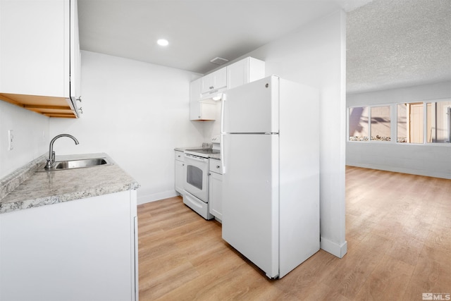 kitchen featuring light countertops, white appliances, a sink, and light wood-style flooring