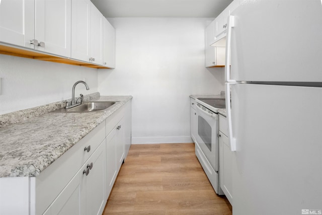 kitchen featuring light wood-type flooring, white appliances, white cabinets, and a sink