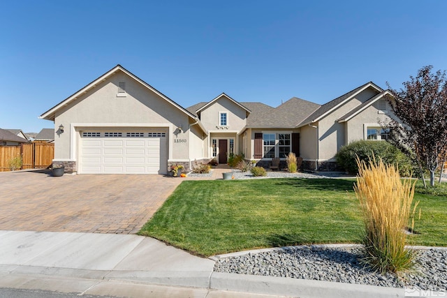 view of front facade featuring stucco siding, an attached garage, fence, decorative driveway, and a front yard