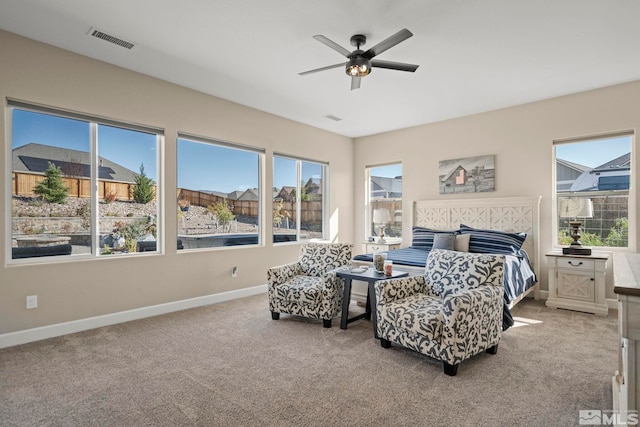 carpeted bedroom featuring baseboards, multiple windows, visible vents, and ceiling fan