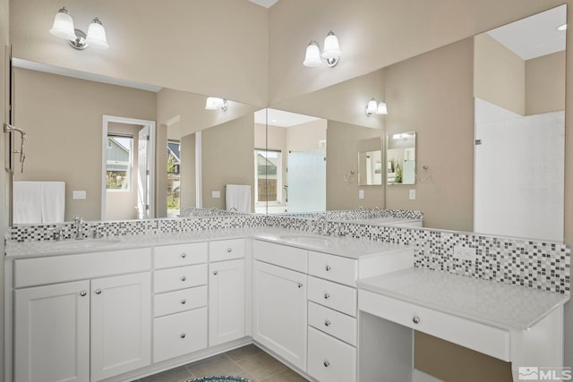 full bathroom featuring double vanity, tile patterned flooring, walk in shower, and a sink