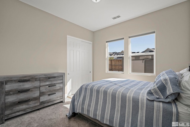 bedroom featuring a closet, visible vents, and carpet flooring