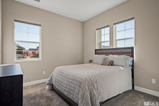 bedroom with multiple windows, carpet, and baseboards