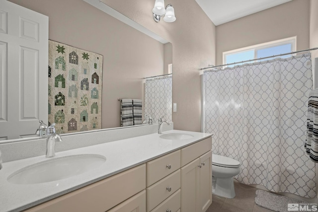 full bath featuring double vanity, a sink, toilet, and tile patterned floors