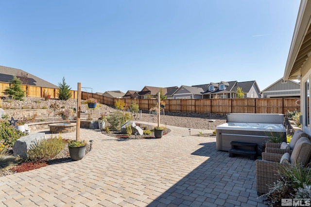 view of patio with a residential view, a fenced backyard, and a hot tub