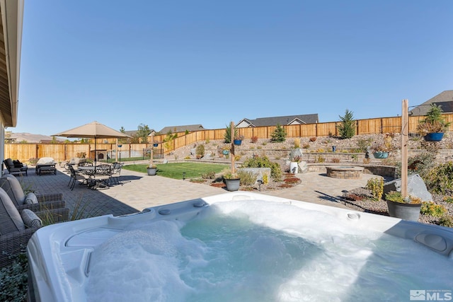 view of swimming pool featuring outdoor dining area, a fenced backyard, a fire pit, a patio area, and a hot tub