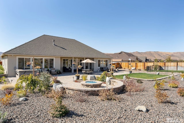 rear view of property with fence, a mountain view, and a patio