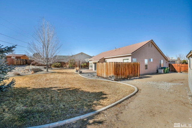 view of home's exterior featuring a yard, fence, and stucco siding