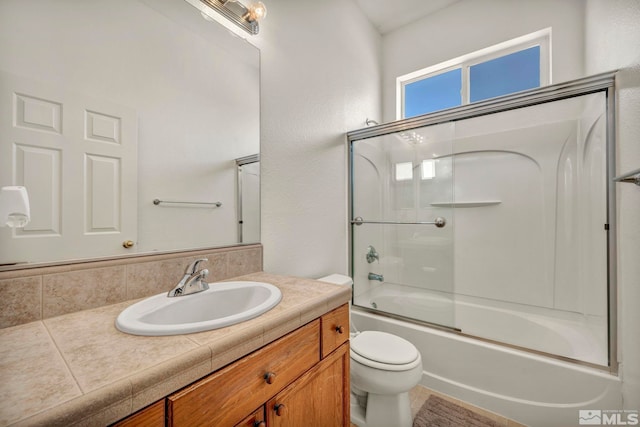 full bath featuring toilet, combined bath / shower with glass door, and vanity