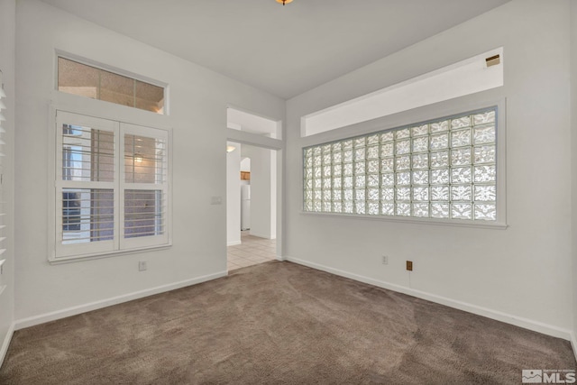 spare room featuring carpet flooring and baseboards