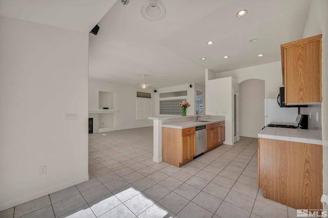 kitchen with dishwasher, ceiling fan, open floor plan, a fireplace, and a sink